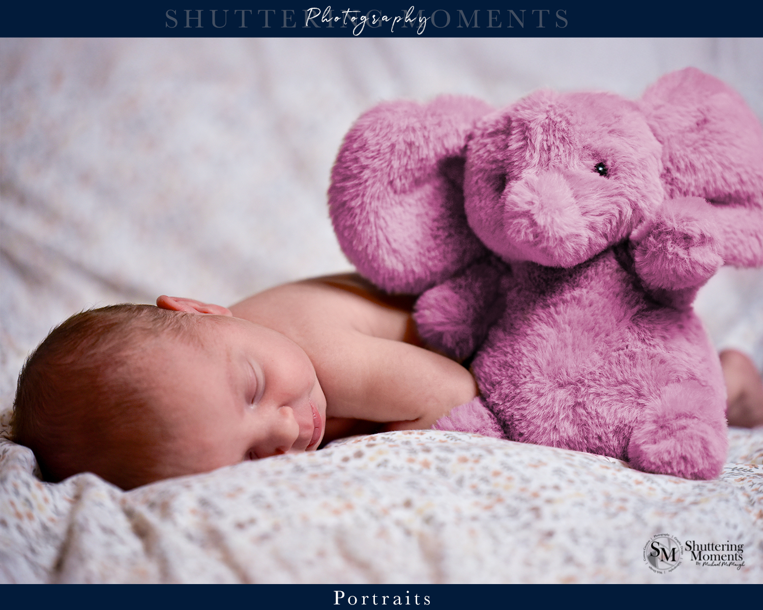 Newborn baby sleeping peacefully on a white blanket with a pink elephant plush toy.